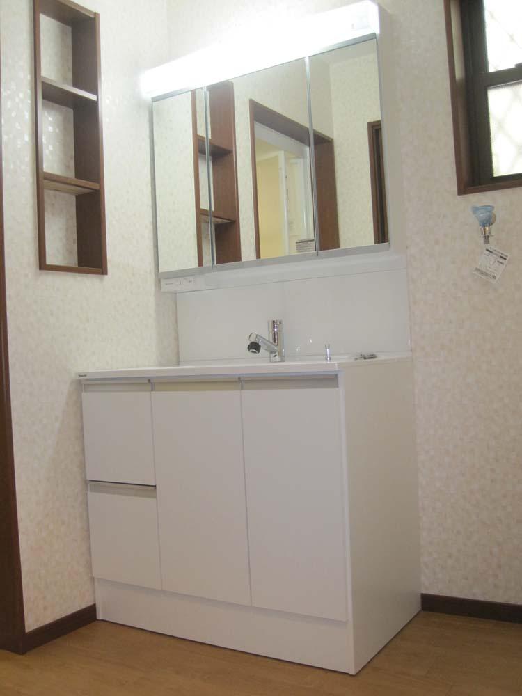 Wash basin, toilet. ■ The back of the three-sided mirror is storage space