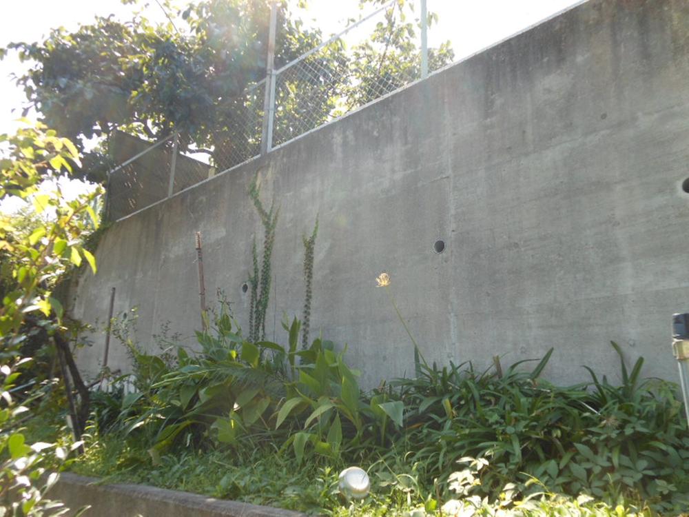 Local appearance photo. In the east site has become a slope.  ※ Property of the retaining wall than in the east site (October 2013) Shooting