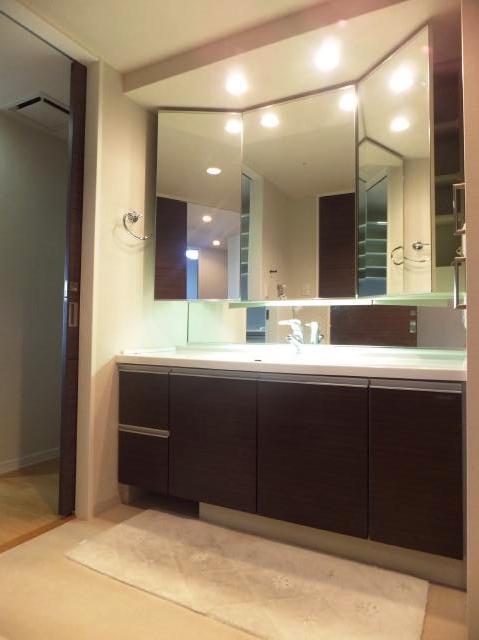 Wash basin, toilet. Vanity is a three-sided mirror.