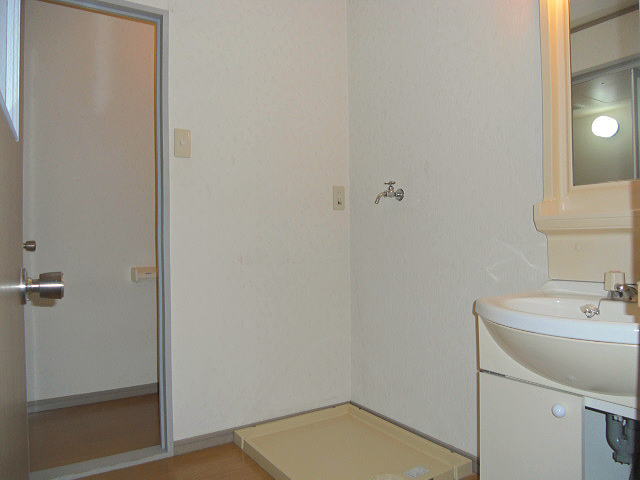 Washroom. Washing machine is put in a room. Photo back is the toilet.
