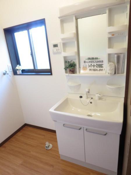 Wash basin, toilet. New vanity with a shower and washing machine inside the room of Cleanup