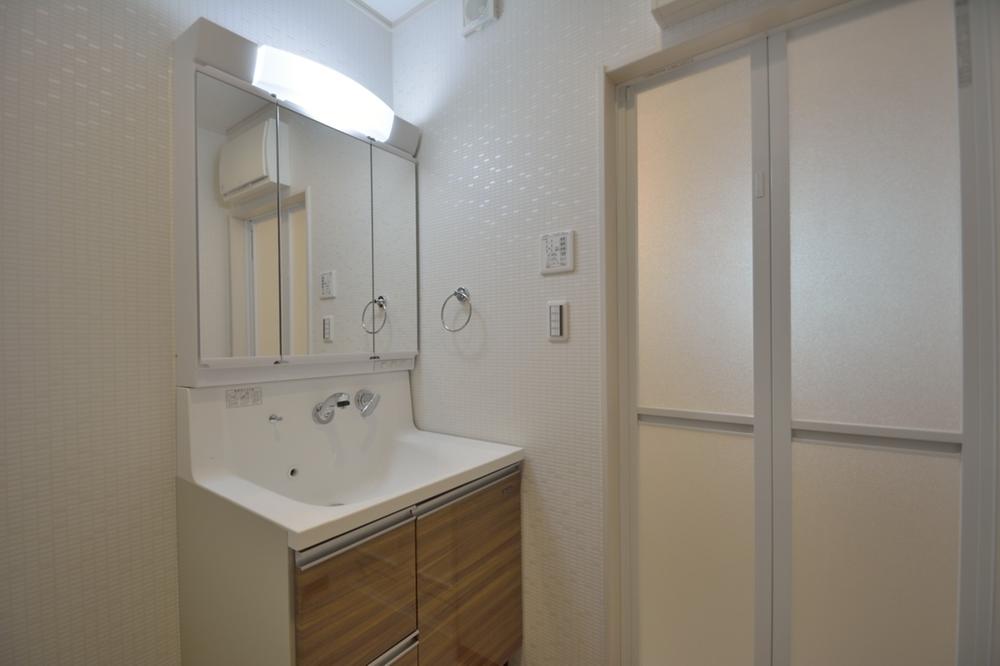 Wash basin, toilet. Tile pattern of wallpaper is pretty washroom.