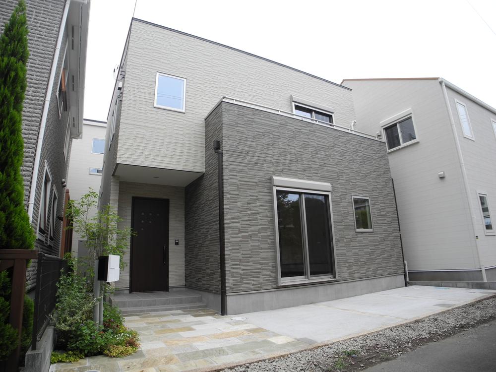 Local appearance photo. (B Building) outer wall is tiled with a profound feeling. A large space achieved by the use of steel in the beam. Floor plan that is clear by the meter module adoption. In particular, the front door ・ Stairs ・ Bathroom space is spacious than the floor plan of the traditional wooden building "scale".