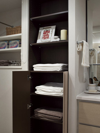 Bathing-wash room.  [Linen cabinet (top open)] Set up a convenient linen warehouse to storage accessories such as towels and detergent. The height of the shelf of the cupboard are adjustable according to the store products.