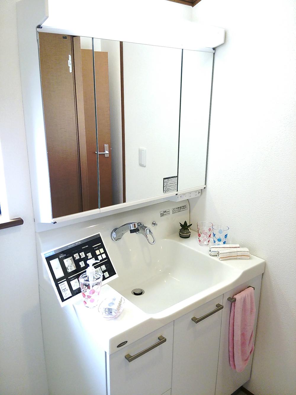 Wash basin, toilet. Vanity is three-sided mirror type, There is also a storage capacity.
