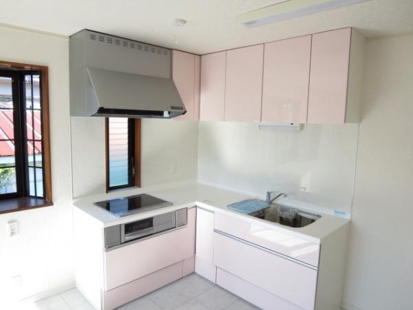 Kitchen. Kitchen is L-shaped in a cute pink. Stove is clean are easy in the IH heater