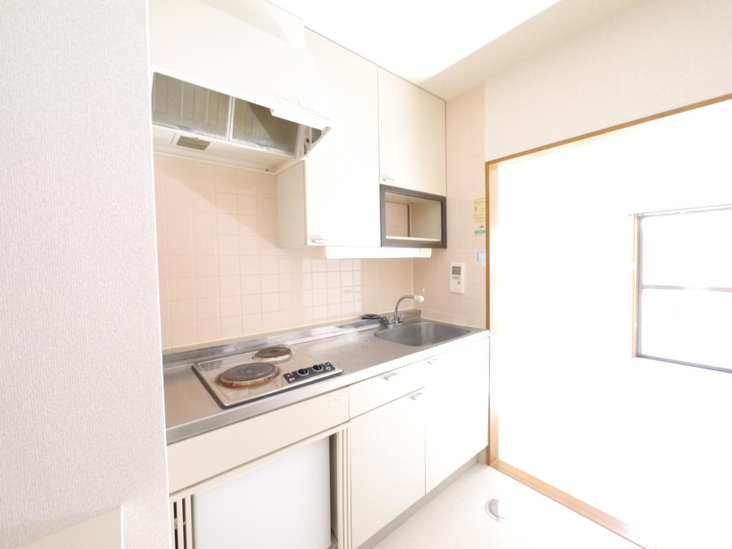 Kitchen. Mini fridge and electric is with a stove