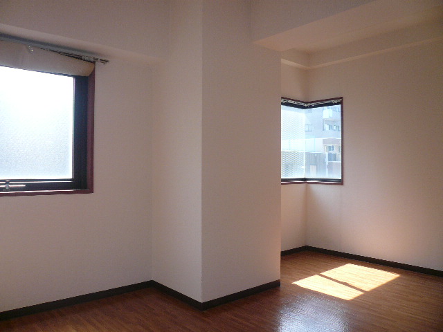 Other room space. There are two windows, It is a bright room. 