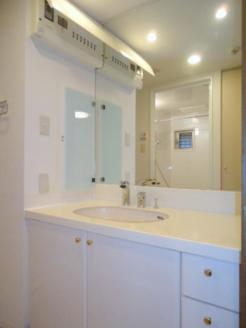 Wash basin, toilet. Vanity large mirror is hotel-like.