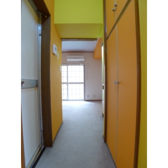Other room space. It is bright yellow and orange wallpaper