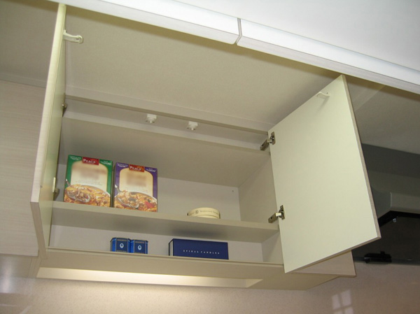 Kitchen.  [Cupboard hanging with lighting space] Sink the top of the Tsuto is, Adopted with lighting to brighten at hand at the time of loading and unloading. Also, Upon sensing the shaking, Jumping door catch function to prevent the storage product comes with.