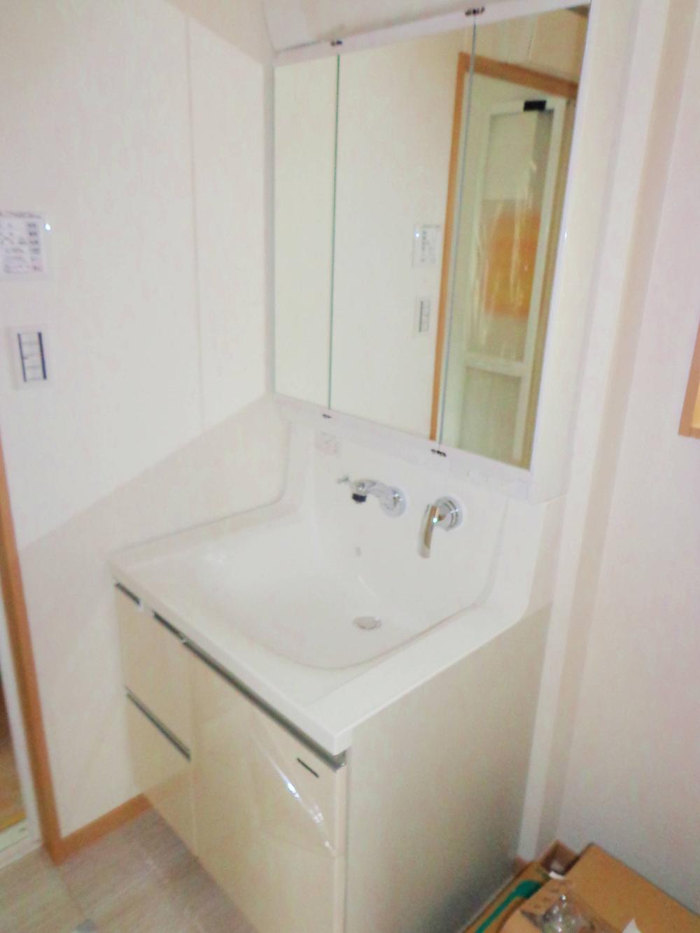 Wash basin, toilet. Vanity of three-sided mirror type shower.