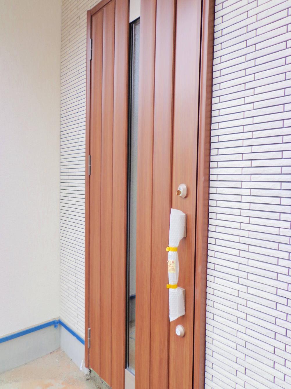 Entrance. Wood-tone front door with a feeling of luxury. Also it features high thermal insulation performance and security features.