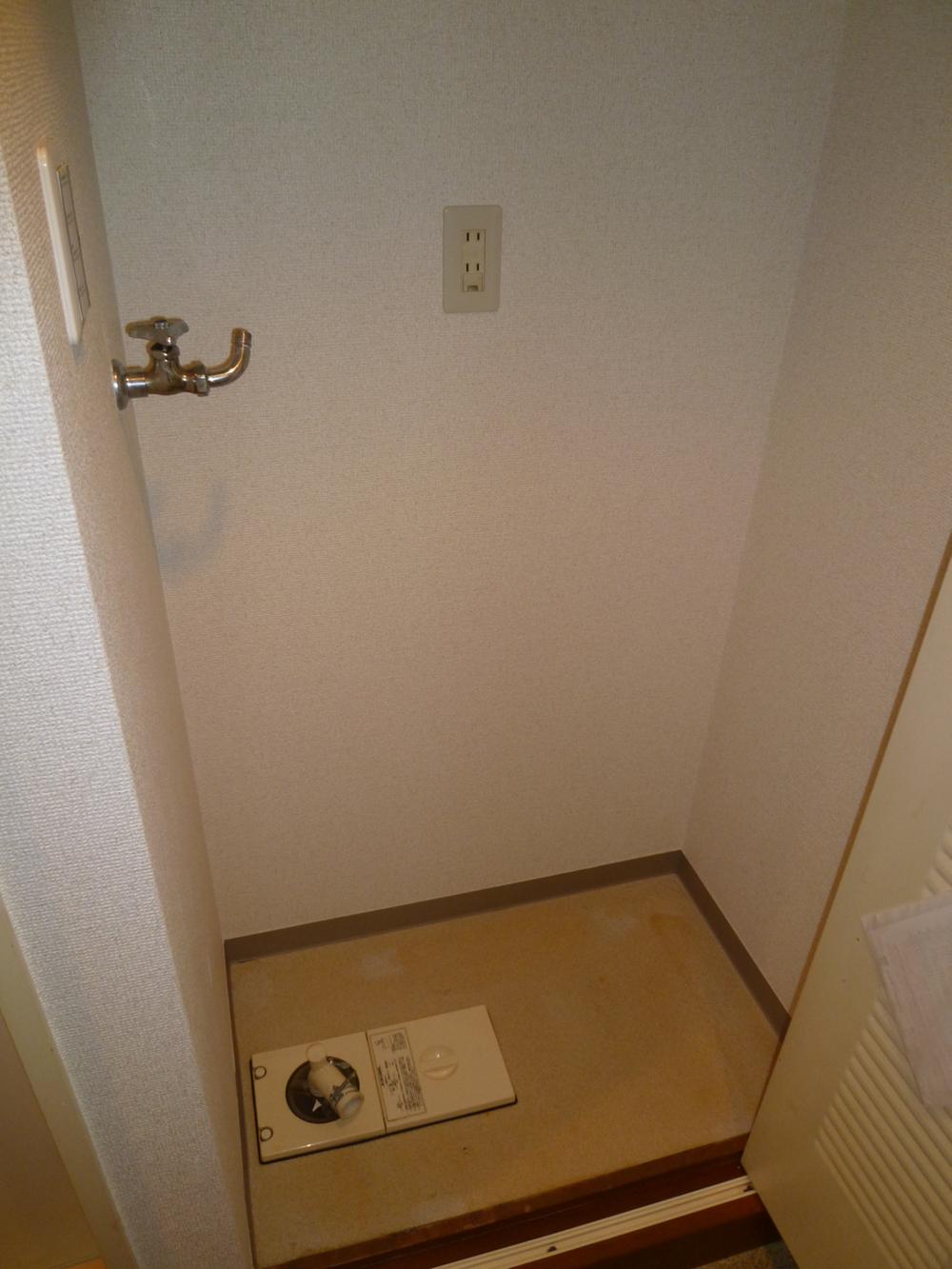 Wash basin, toilet. Washing machine in the room with