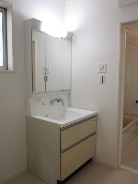 Wash basin, toilet. Three-sided mirror vanity with storage shower faucet