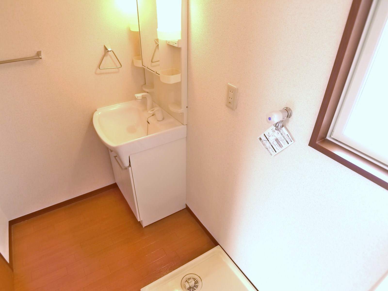 Washroom. Wash room shower-type sink and washing machine inside the room with a small window is a space