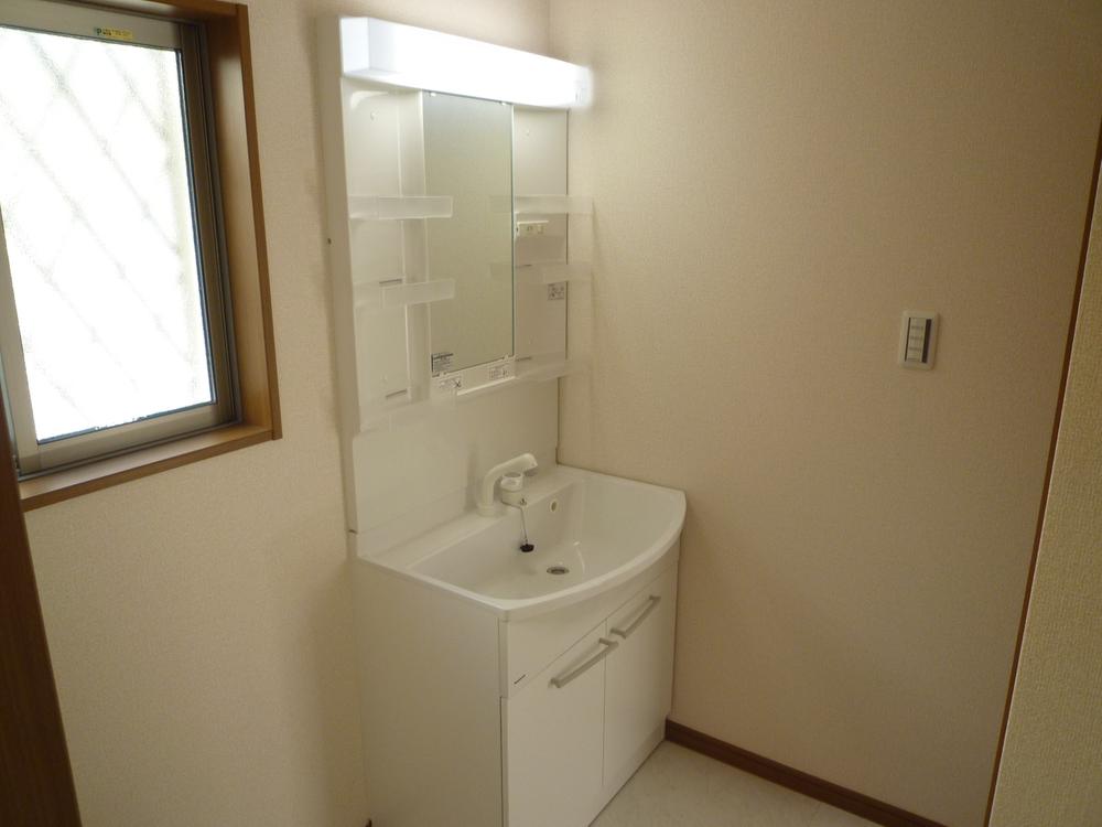 Wash basin, toilet. Equipped with a vanity with shower.