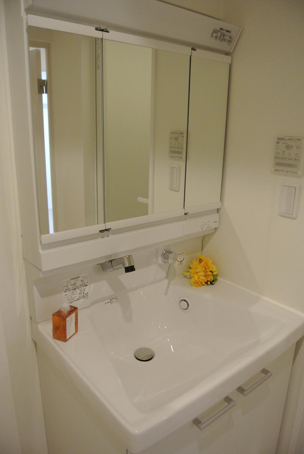 Wash basin, toilet. Vanity with a three-sided mirror