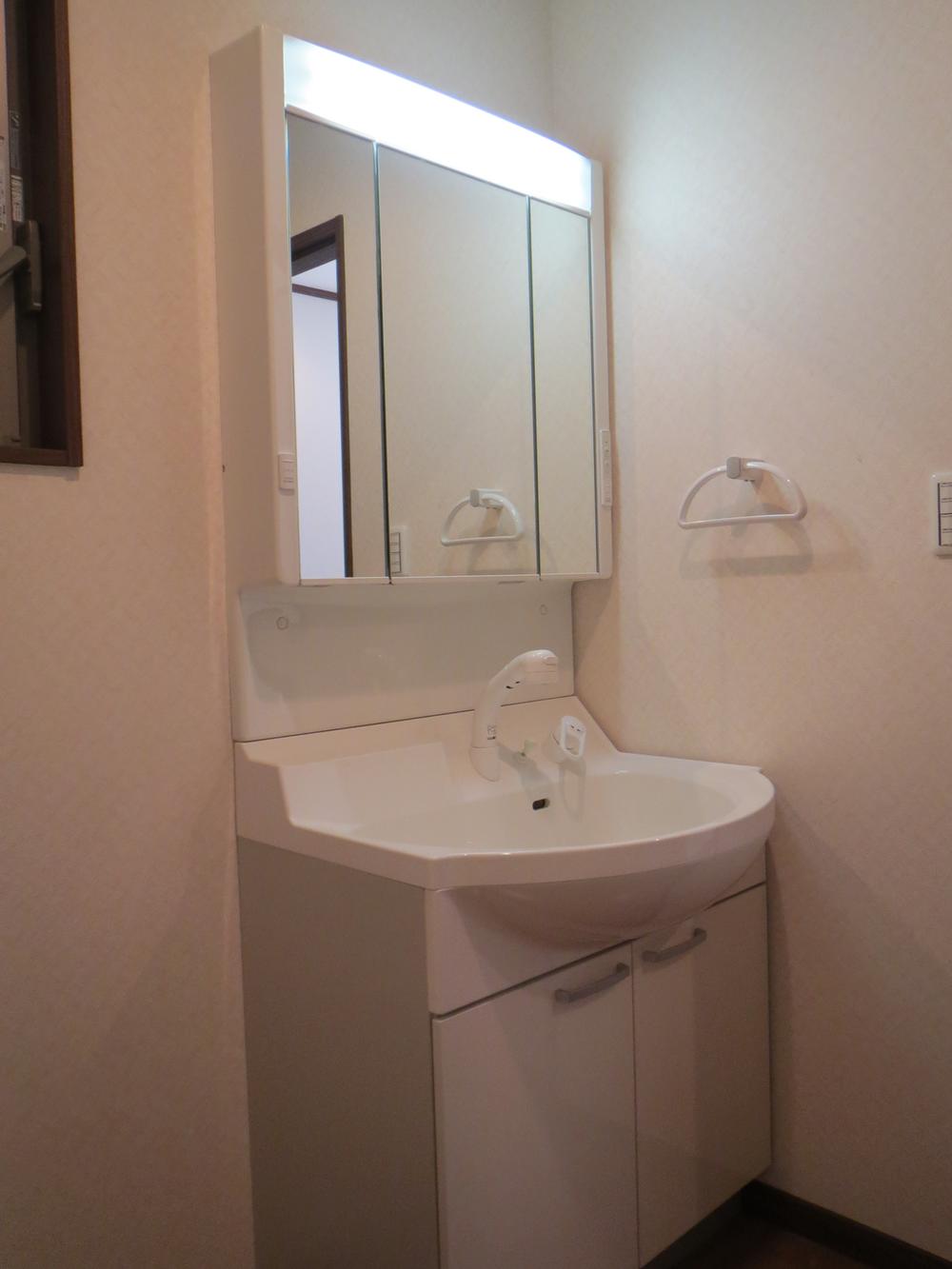 Wash basin, toilet. There is storage space in the back of the three-sided mirror