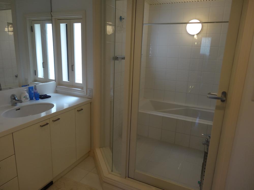 Wash basin, toilet. Bathroom door is a stylish glass.