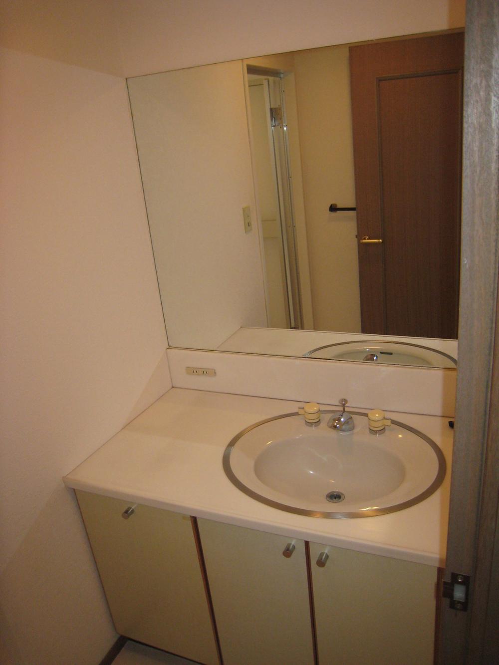Wash basin, toilet. Vanity with a large mirror