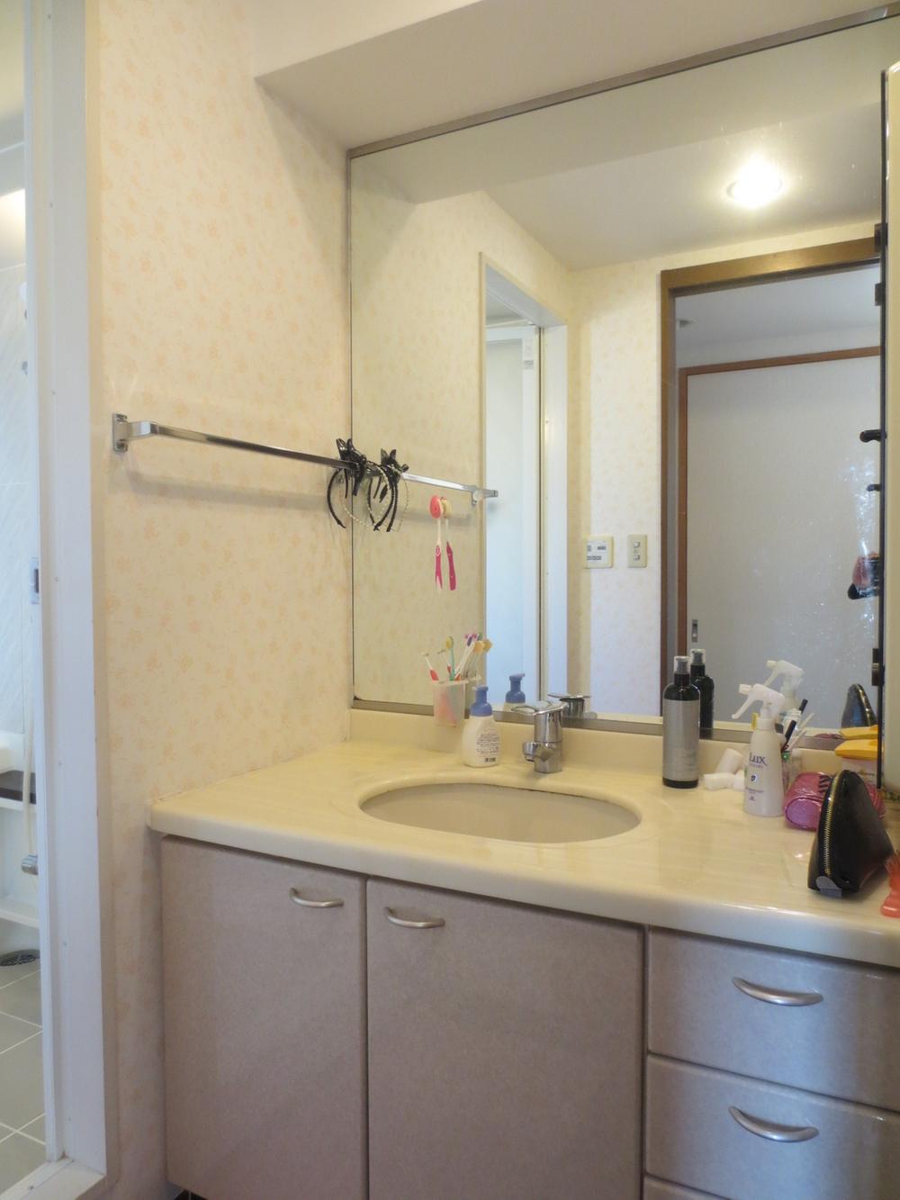 Wash basin, toilet. Vanity with a large mirror.