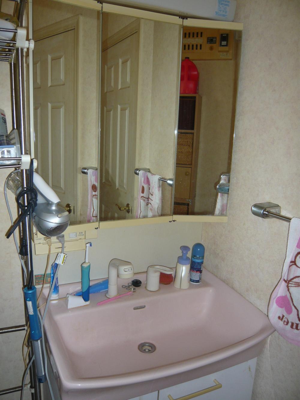 Wash basin, toilet. Vanity with a three-sided mirror
