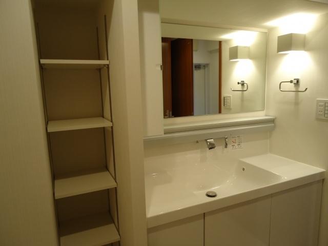 Wash basin, toilet. Storage space have to washroom next to