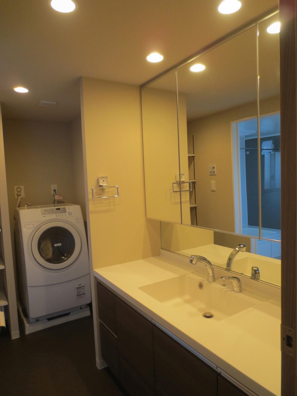 Wash basin, toilet. Vanity with a large three-sided mirror. Storage is also abundant