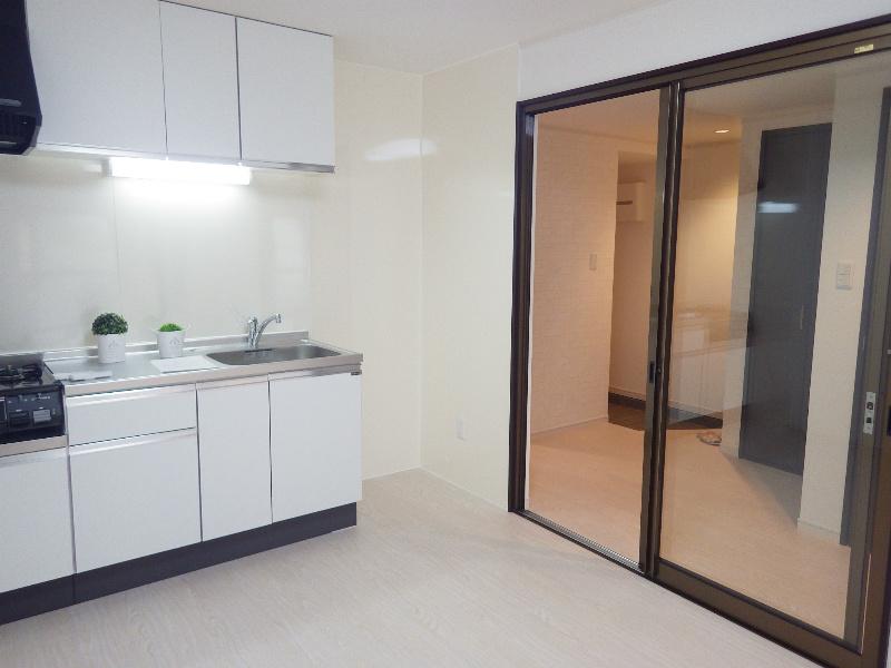 Kitchen. Open door leading to the hallway is made of glass