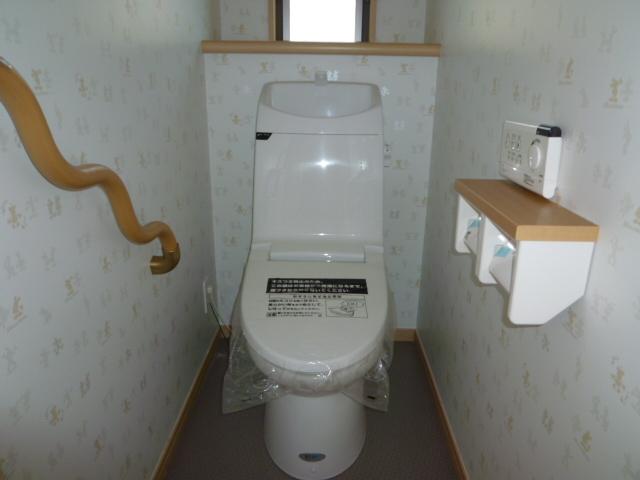 Toilet. Toilet with a handrail