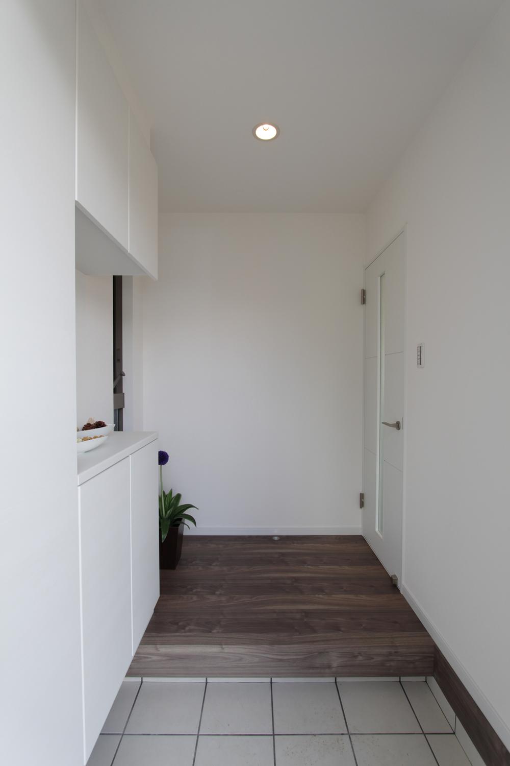 Entrance. Shoebox that was unified with the wallpaper. Is available houses a lot of shoes in it.