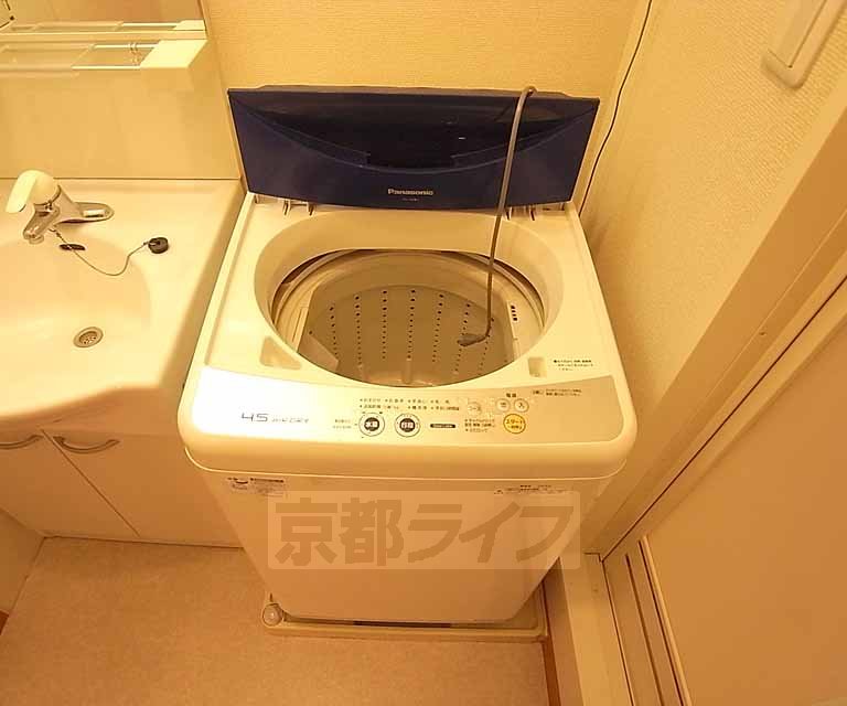 Washroom. It has a washing machine with.