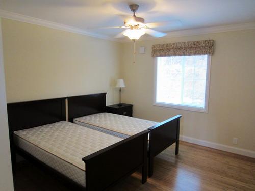 Non-living room. Two bets It is the first floor master bedroom of with a ceiling fan.