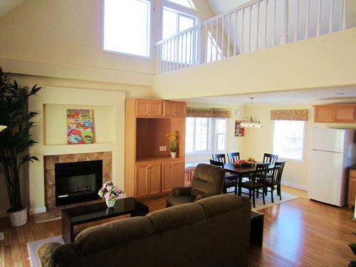 Living. A living room with a fireplace, dining, The middle is a TV stand.