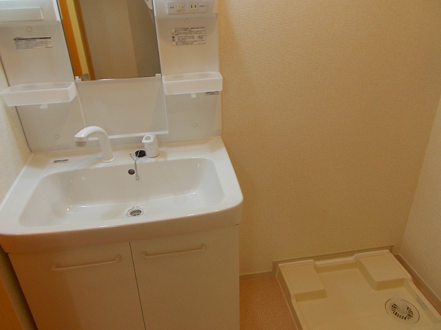 Washroom. Wash basin next to the washing machine storage