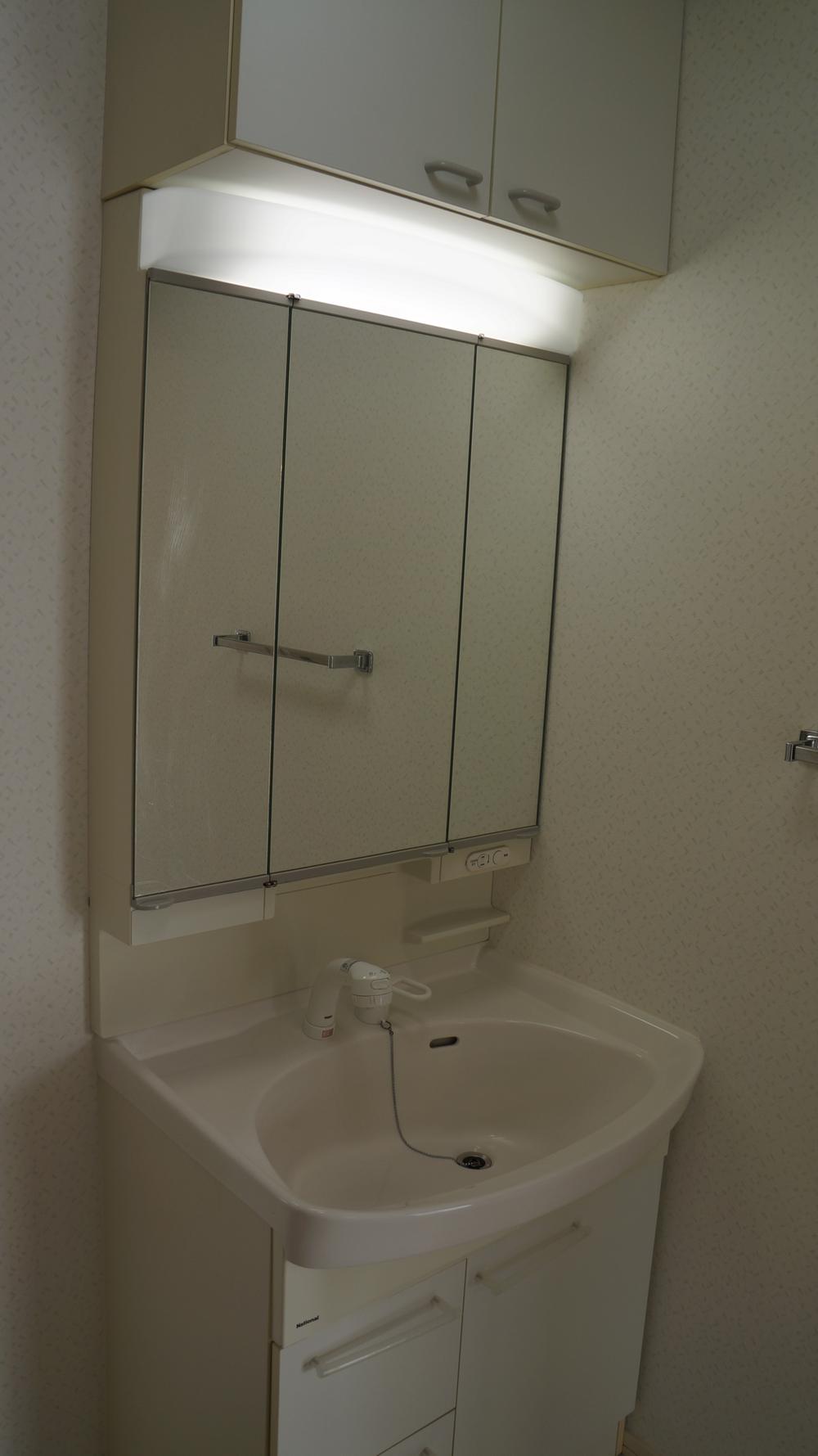Wash basin, toilet. Vanity with a three-sided mirror