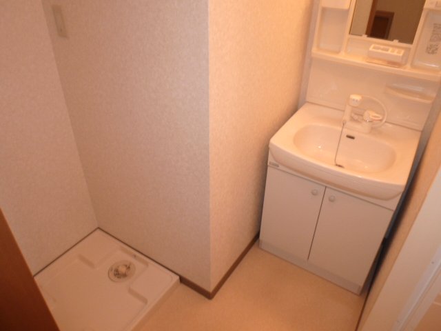 Washroom. There is a washing machine inside the room. 