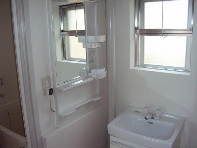 Wash basin, toilet. It is very bright there is a light shines window to wash room.