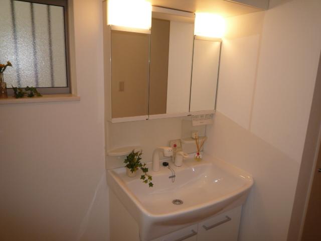 Wash basin, toilet. With bright light in the three-sided mirror! 