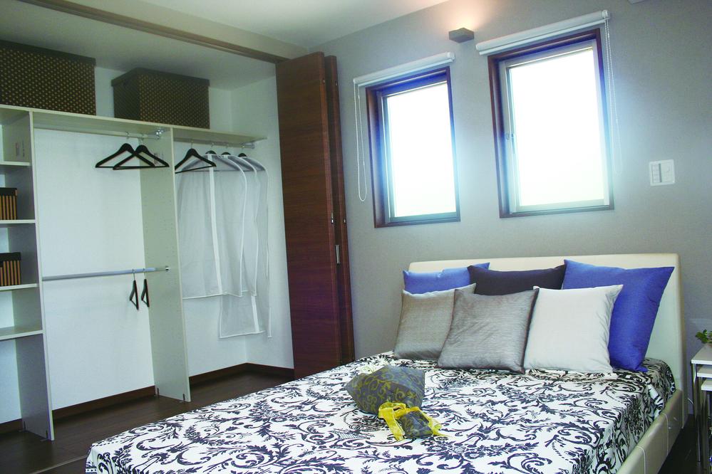 Model house photo. Bright bedroom facing the bedroom balcony is provided with a high storage capacity closet.