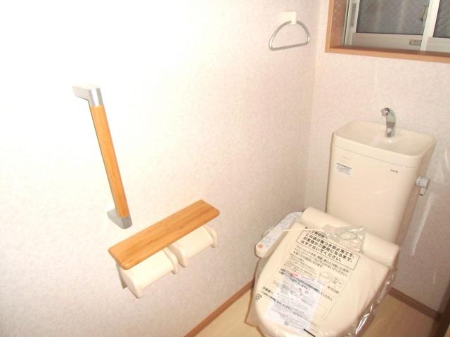 Toilet. Cleaning feature with toilet seat