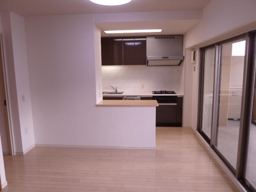 Living. It is a photograph of the kitchen side from the living room. With counter in the kitchen.