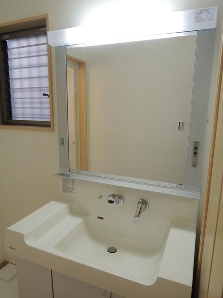 Wash basin, toilet. Surprised to large mirror. Likely to be the same a set and beauty salon.