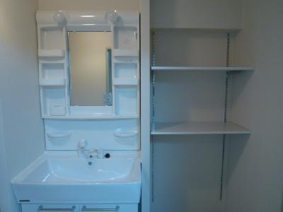 Washroom. Storage shelves of the wash basin next to is useful