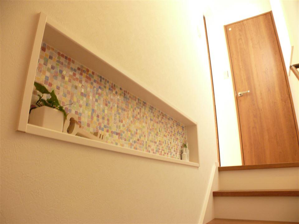 Model house photo.  [Model house] By providing a niche in the stairs of the wall and the living room, Display small items. Choice and mosaic tiles also match the atmosphere of the interior.