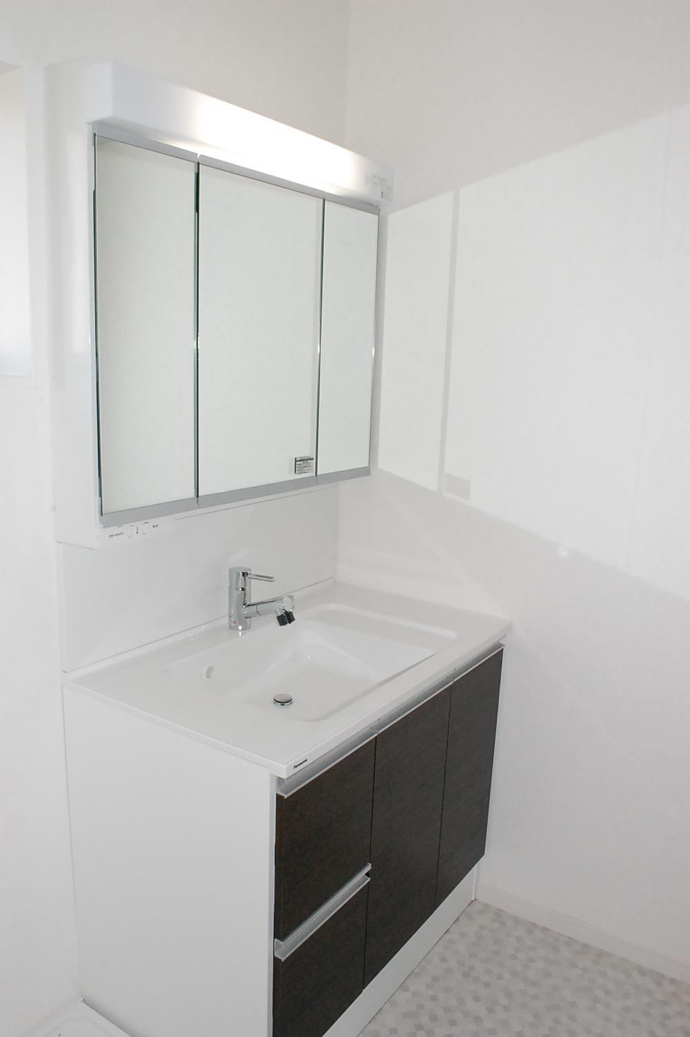 Wash basin, toilet. Panasonic vanity. Shower Faucets. Wide three-sided mirror.
