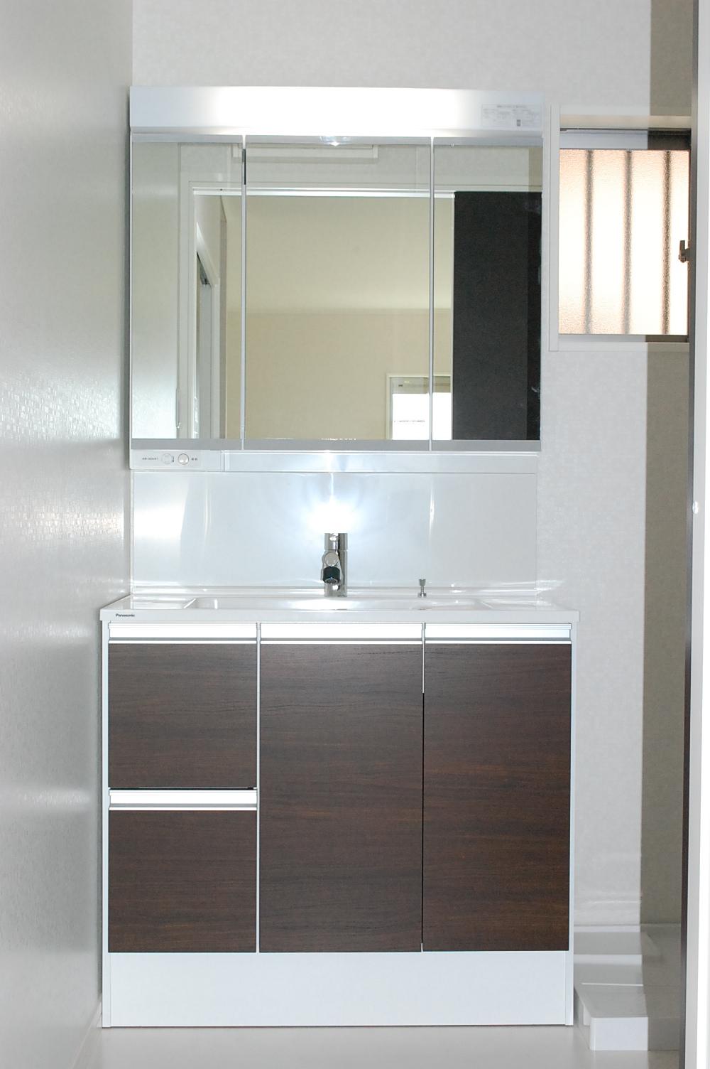 Wash basin, toilet. LIXIL made vanity. Shower Faucets. Wide three-sided mirror.