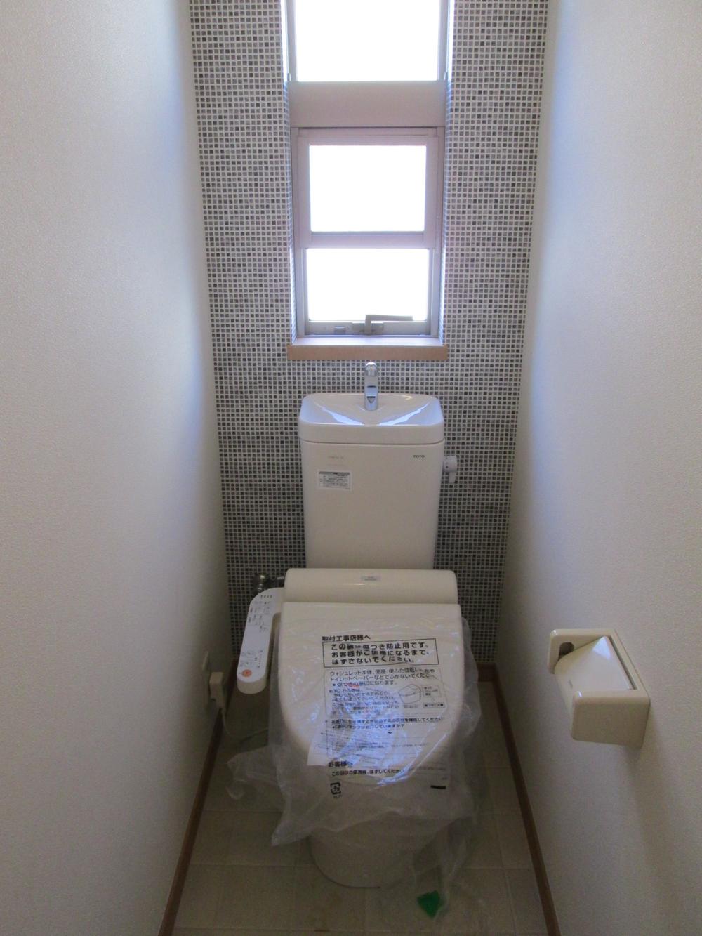 Toilet. It is a window with a very bright restroom.