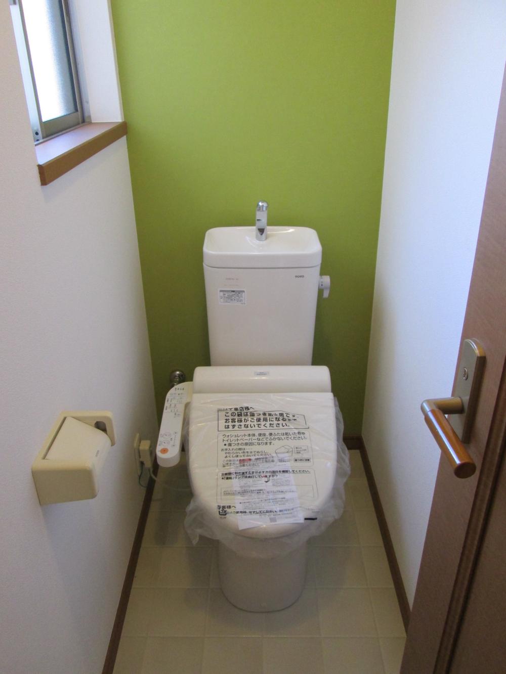 Toilet. Feeling good restroom with green walls and lighting preeminent.